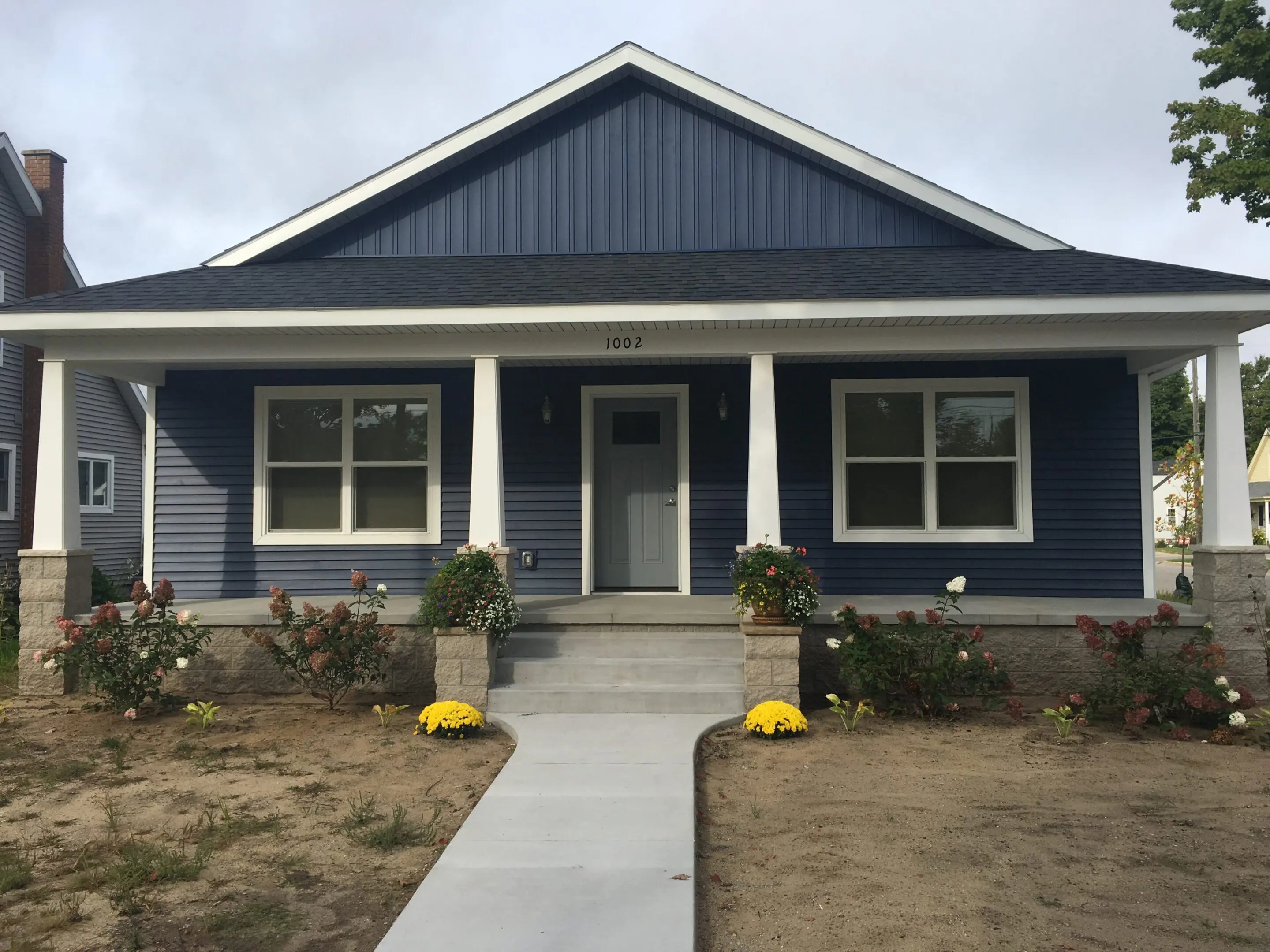 Blue craftsman-style house with a front porch and steps.